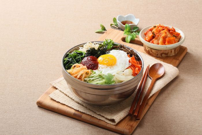 bibimbap in a stainless-steel bowl on a tray