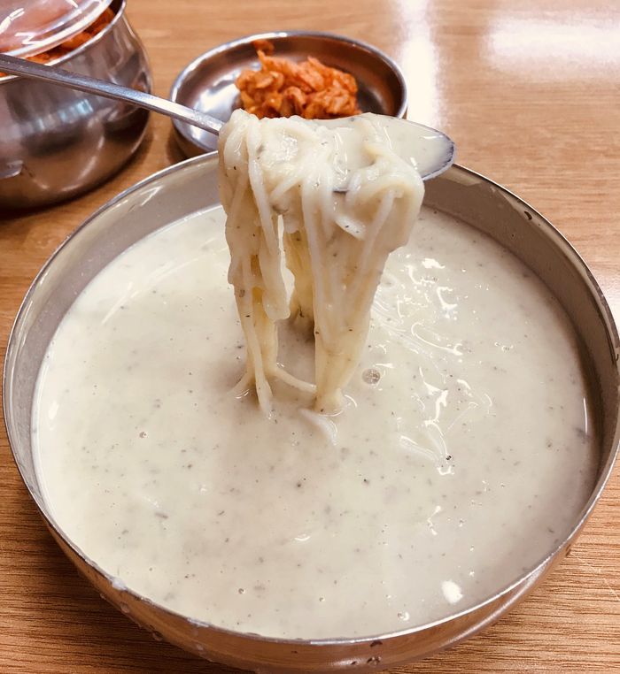 kong-guksoo being lifted out of a bowl with a spoon